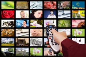 Close up of a hand holding a remote control with a television concept.