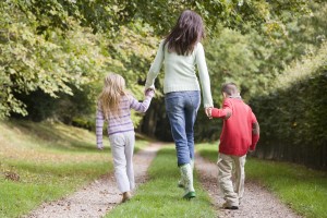 Mother and children walking on woodland path